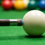 Nahaufnahme eines Snooker-Frames mit Queue-Stoss auf die weisse Kugel