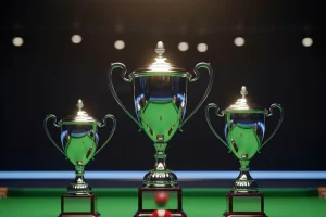 Drei Snooker-Pokale der Triple Crown nebeneinander auf grünem Filz